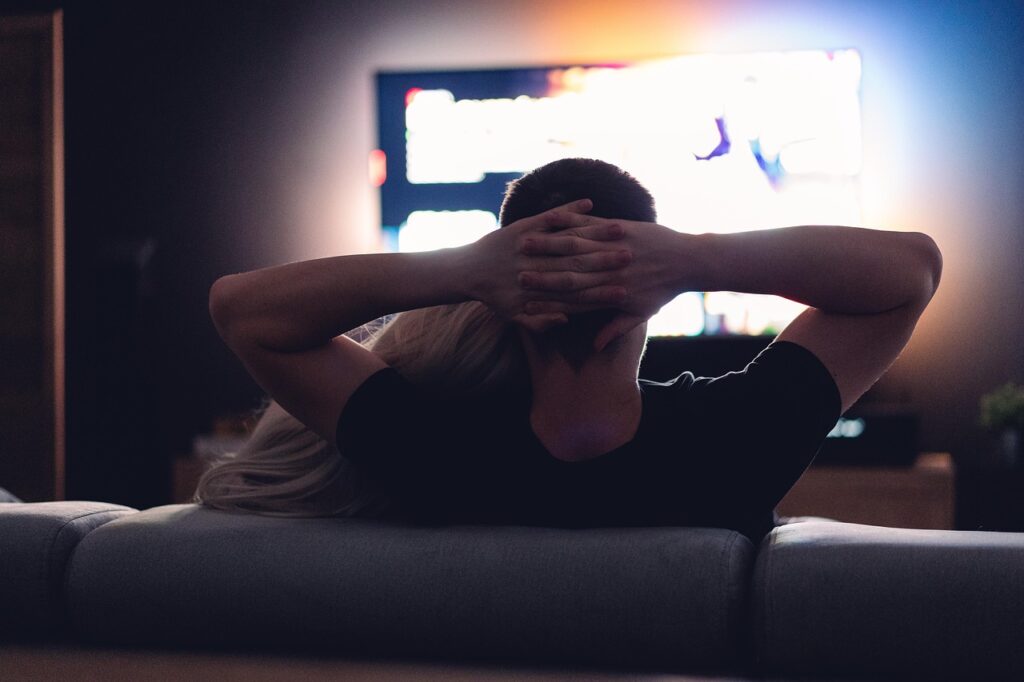 暗い部屋でテレビを見るカップル