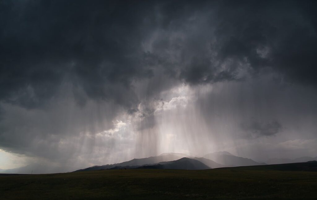暗い雨雲が広がる空と虹