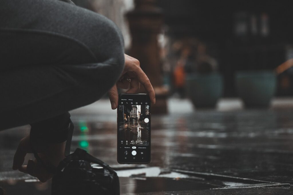雨の中スマートフォンを手に持つ様子