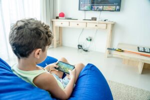 スマートフォンでゲームを楽しむ笑顔の子ども