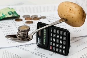 電卓とコイン、家計簿で予算を計算している様子